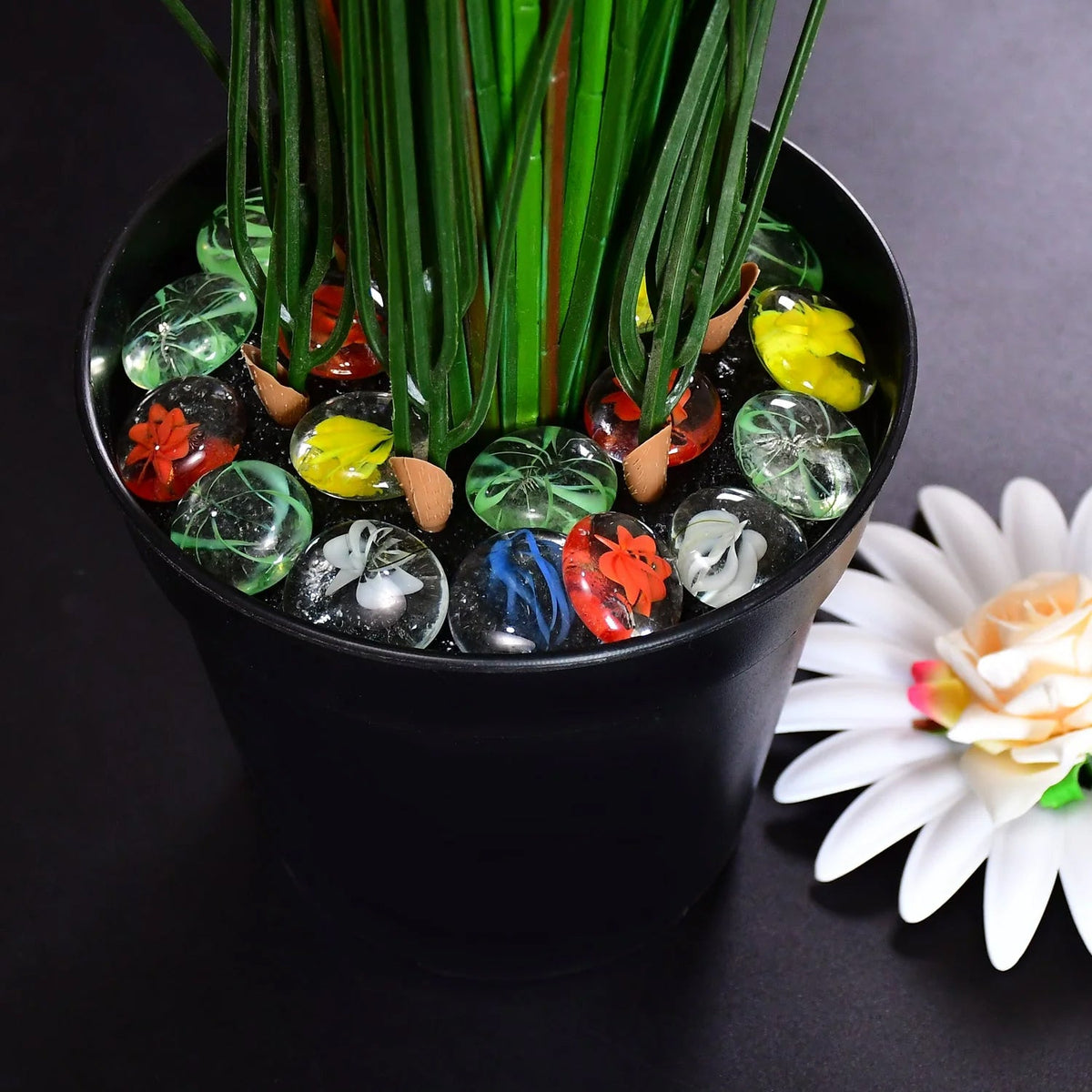 Vibrant multi-color pebbles elegantly arranged in a small plant pot.