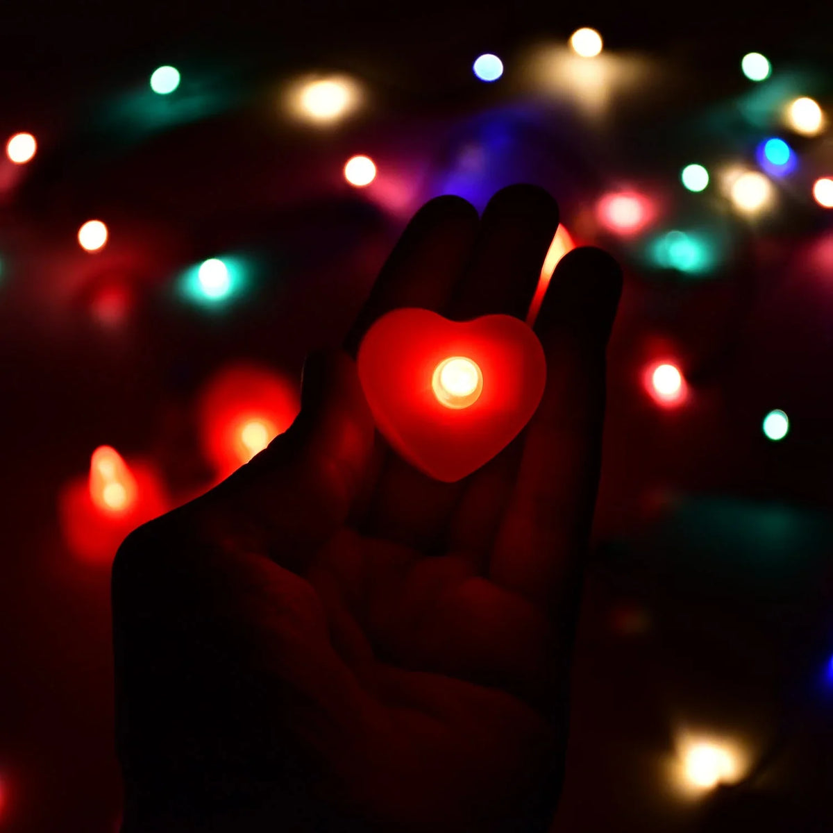 Heart-shaped flameless tea lights illuminating a dark room for Diwali.