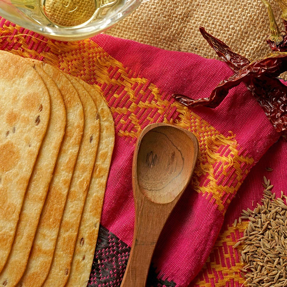Stack of round, golden-brown Khakhra wheat chips.